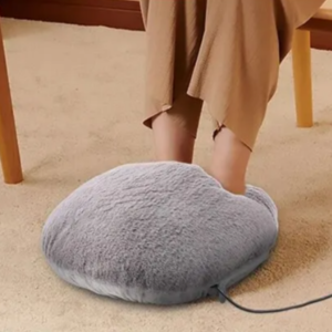 Femme utilisant un chauffe-pieds posé au sol.