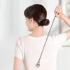 "Personne utilisant un gratte dos télescopique pour atteindre le haut du dos"