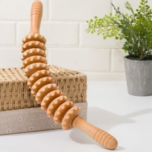 Rouleau de massage posé sur une boite en paille.