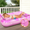 Femme bronzant sur un flotteur piscine dans son jardin ou sur sa terrasse.