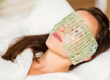 Femme allongée sur un lit avec un masque pour les yeux, symbole de calme et de sérénité dans une ambiance de détente absolue.