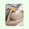 Femme tenant un appareil sommeil naturel dans son lit pour faciliter l’endormissement.
