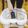 Femme manipulant la tête ionique du bain de pieds Ionix Spa™ pendant sa séance détox.