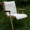Coussin chauffant USB en tissu doux installé sur une chaise en bois dans un jardin.