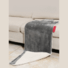 Coussin chauffant USB gris en imitation cachemire posé sur un canapé clair.
