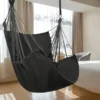 Chaise hamac suspendue grise installée dans une chambre moderne et lumineuse