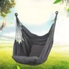 Chaise hamac suspendue grise avec coussin, vue en extérieur dans un jardin