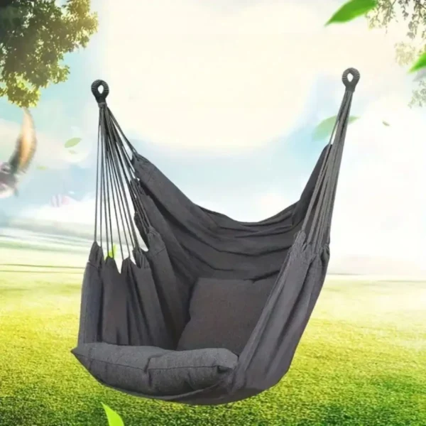 Chaise hamac suspendue grise avec coussin, vue en extérieur dans un jardin